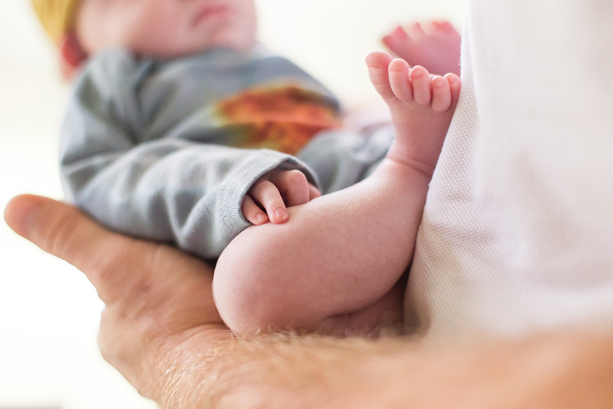 baby's feet rest on dad's chest