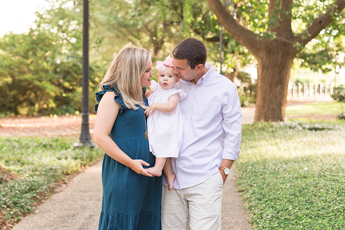 mom and dad kiss baby girl on the cheek during family portraits at the SC State house