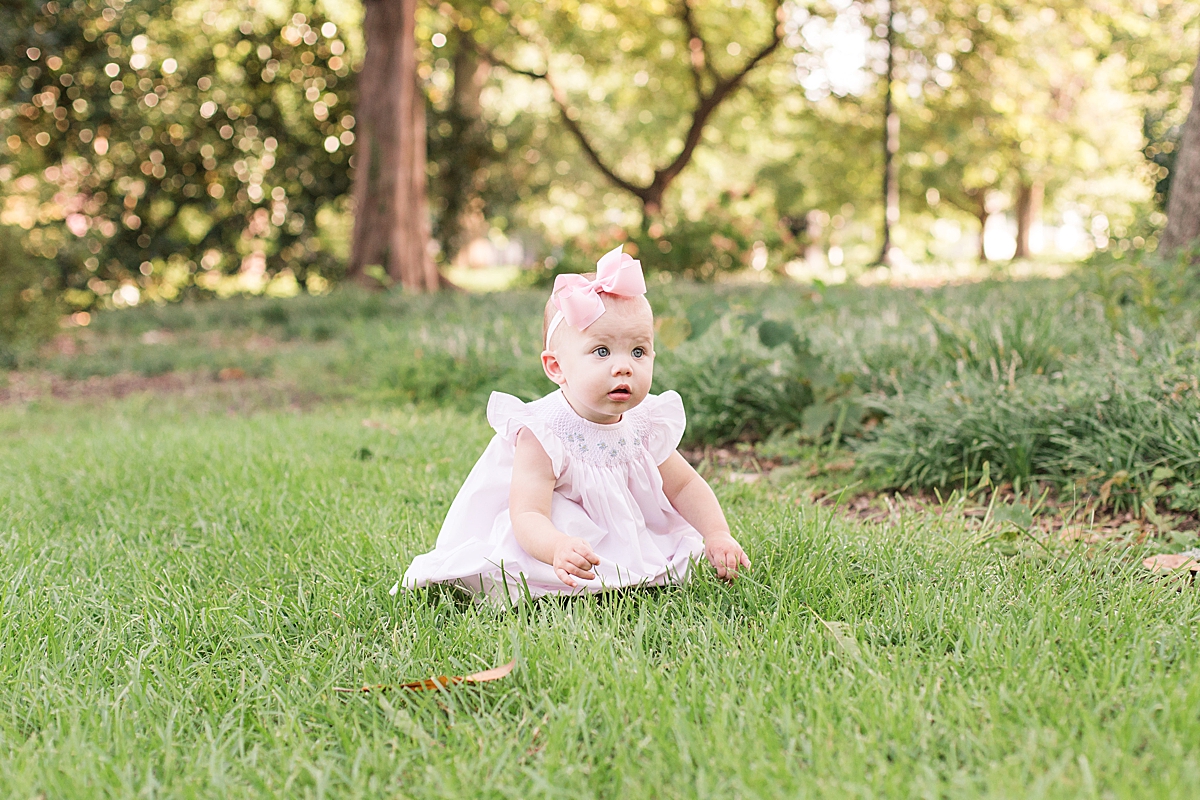 one year old sits in grass during first year milestone portraits