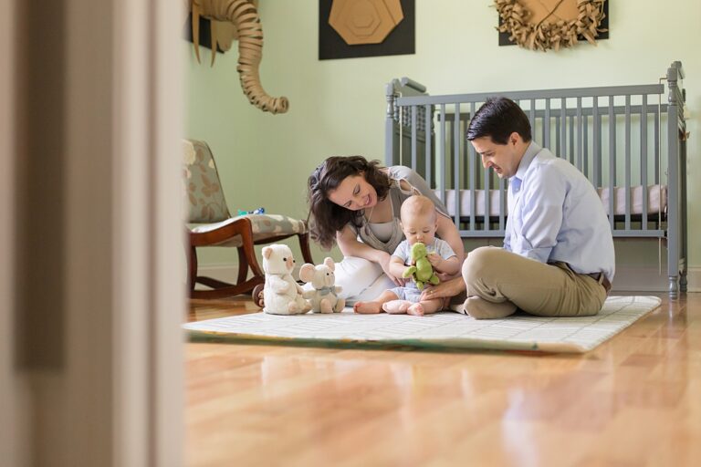 family of three play on floor of nursery during in-home lifestyle session