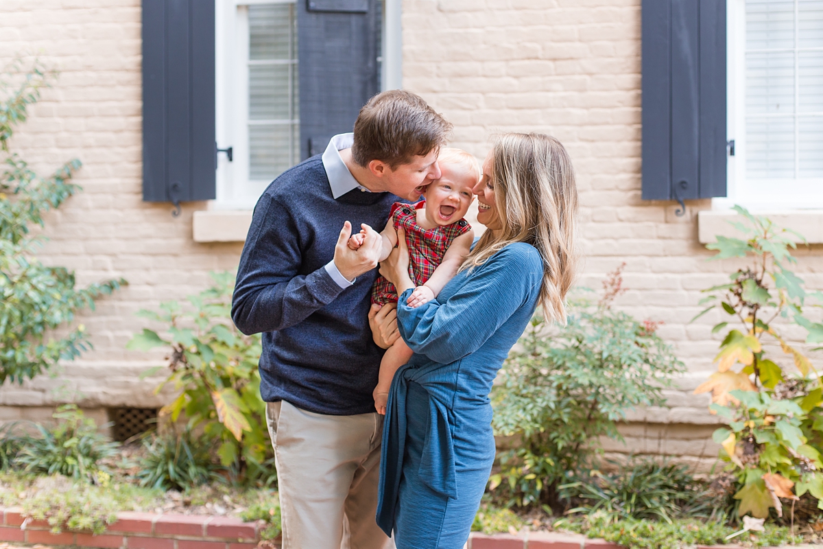 parents kiss their happy son during SC family portraits at USC Horseshoe 