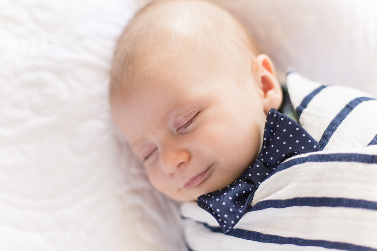 baby sleeps soundly with a smile on his face during in-home cozy lifestyle newborn session in SC