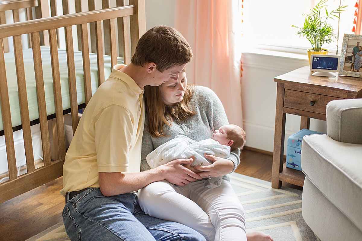 parents sit by crib during In-Home Newborn Lifestyle Session