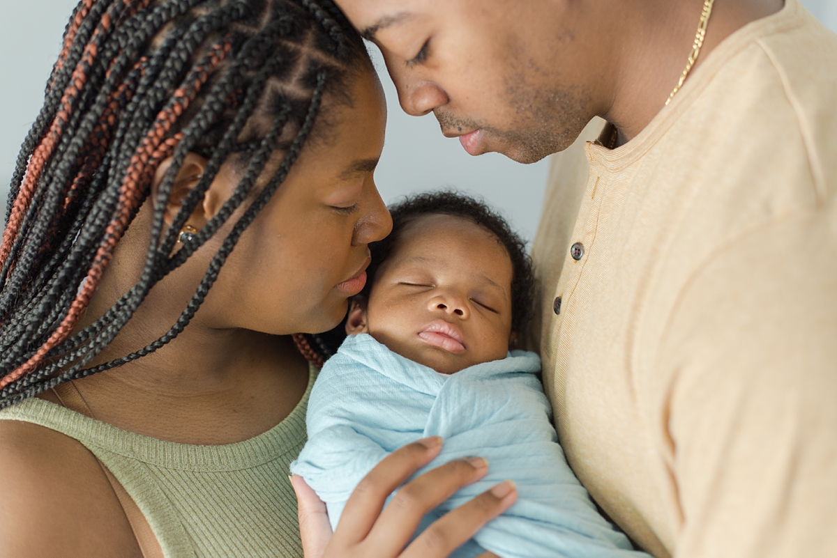 parents hold baby at home during newborn session