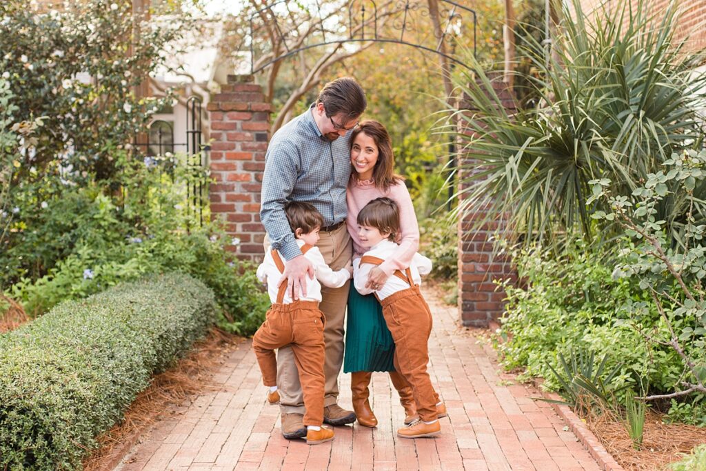 family of four hugs during fall family portraits at USC Horseshoe in Columbia SC