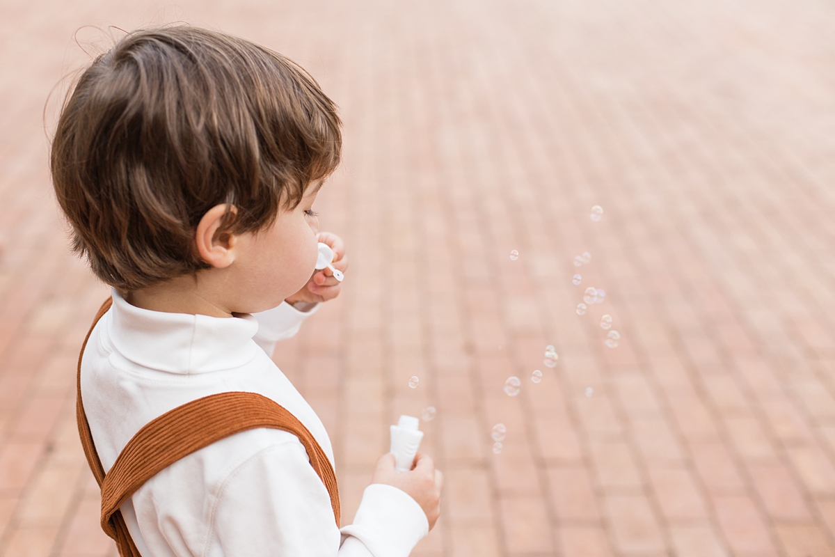 young boy blowing bubbles